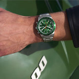 Man's wrist with a green and silver watch.
