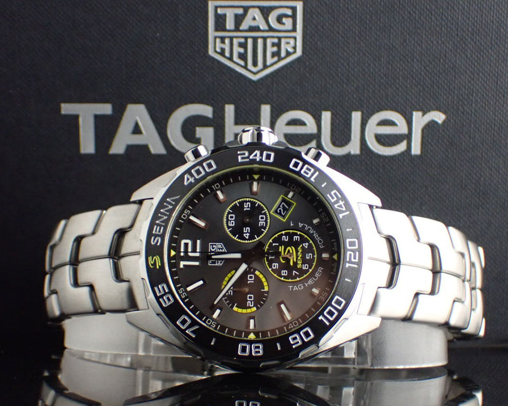 Silver TAG Heuer watch with black dial and bracelet.