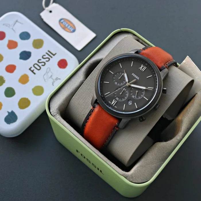 Fossil watch in box with orange leather strap.