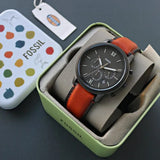 Fossil watch in box with orange leather strap.