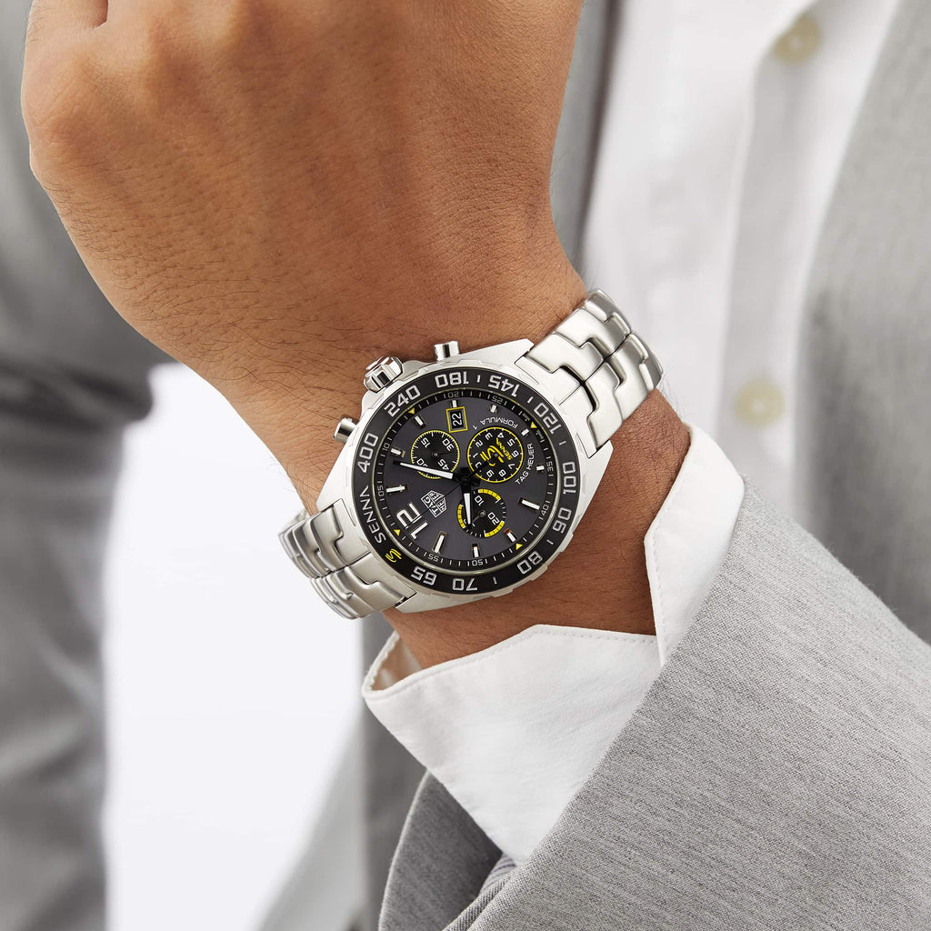 Man's wrist wearing a silver wristwatch.