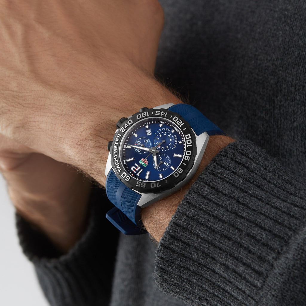Man wearing a blue and silver wristwatch.