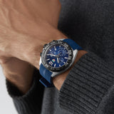 Man wearing a blue and silver wristwatch.