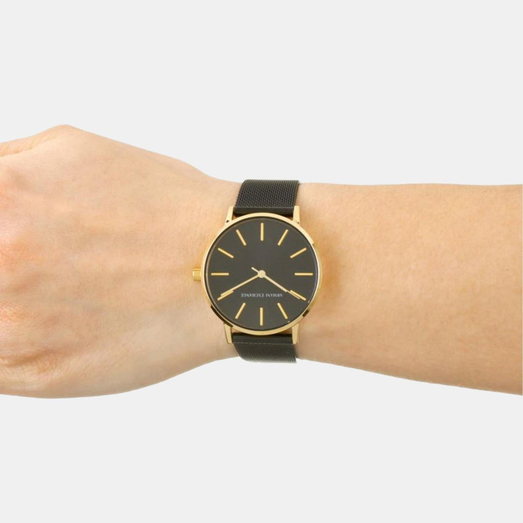 Black and gold wristwatch on wrist
