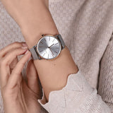 Person wearing a silver wristwatch.