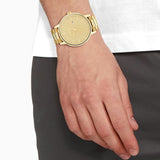 Man wearing a gold wristwatch.