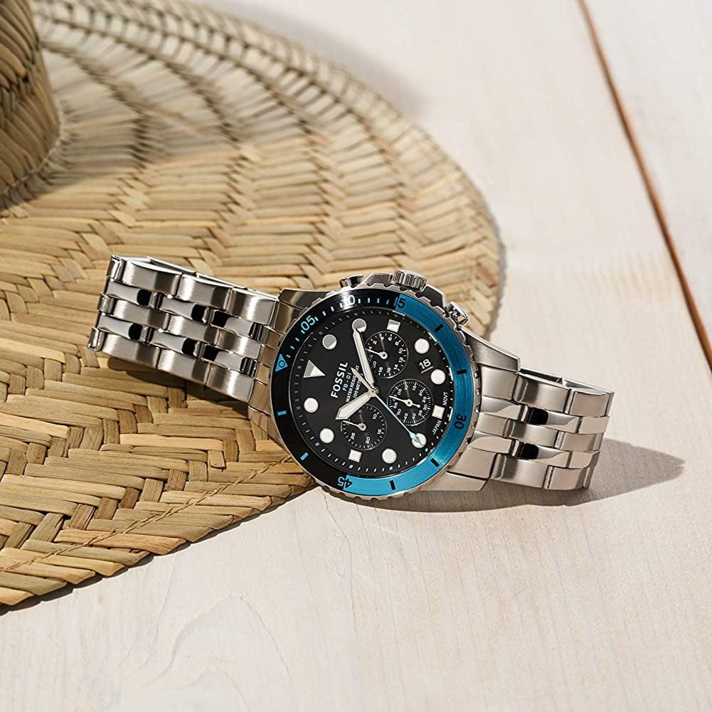 Fossil watch with blue bezel on woven surface