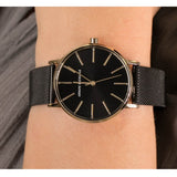 Wrist with a black Armani Exchange watch.