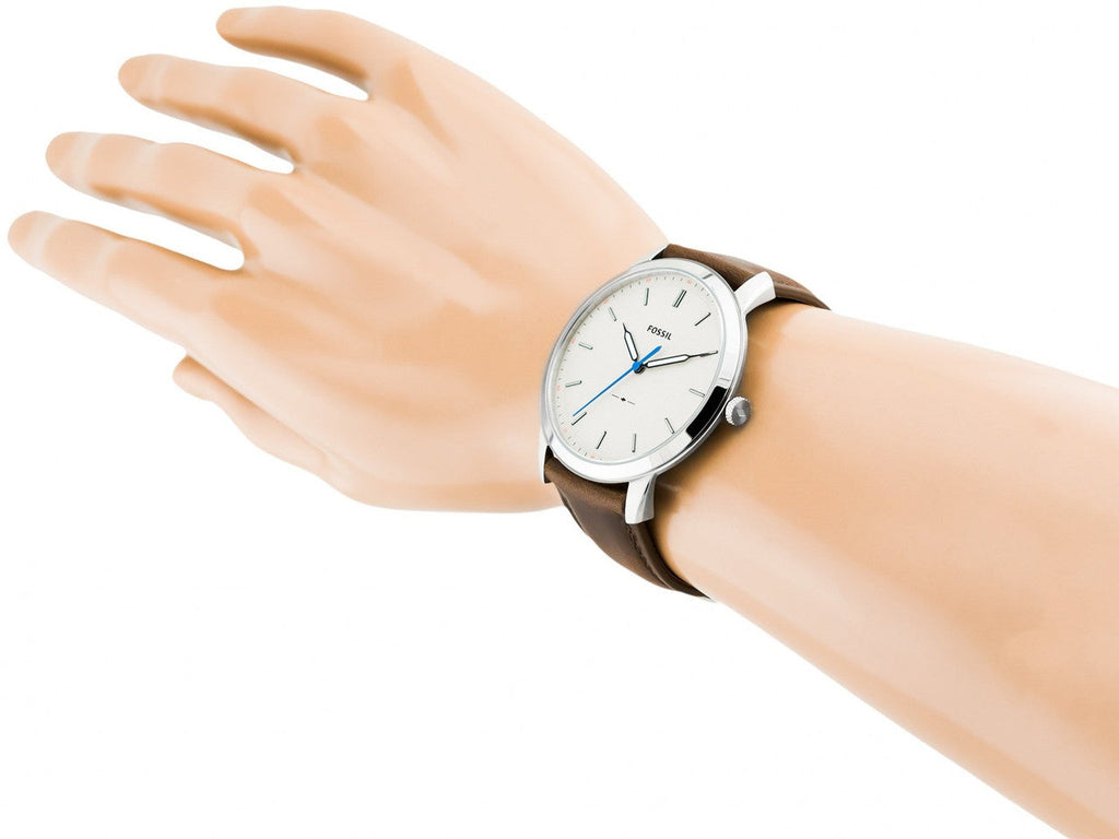 Wrist wearing a wristwatch with brown strap.