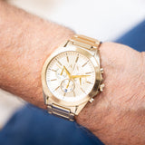 Gold wristwatch on a wrist.