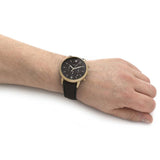 Fossil watch on wrist, black and gold design, 3231468b26461e6898aecacf35a339ad