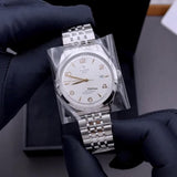Silver wristwatch in plastic wrap.