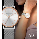 Woman wearing two silver and rose gold Armani Exchange watches.