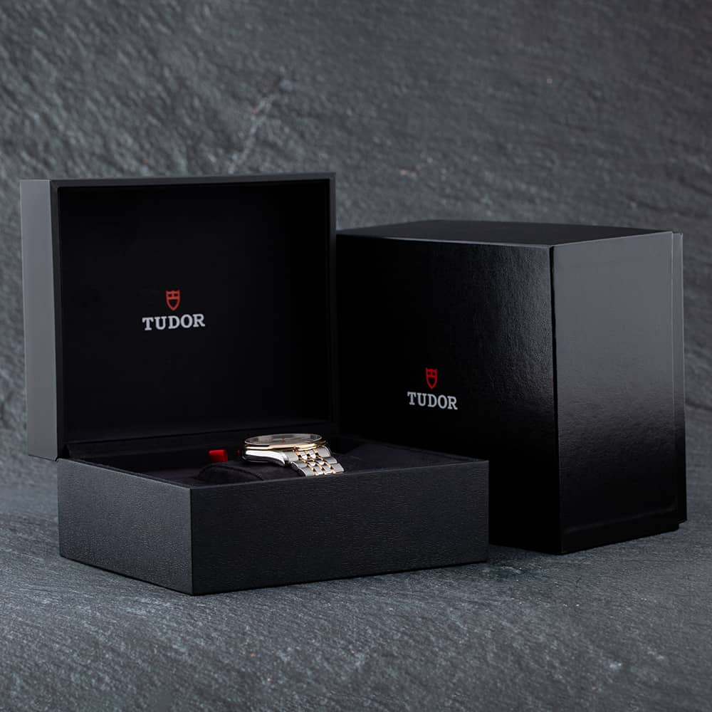 Black watch box with Tudor watch inside.