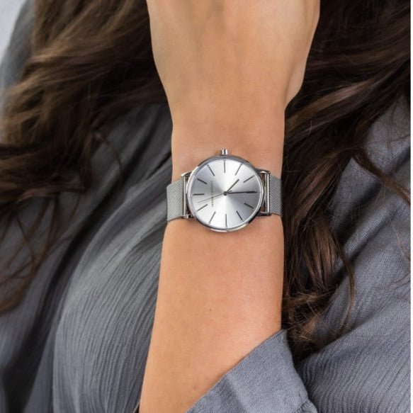 Woman's arm wearing a silver watch.