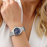 Woman wearing a silver watch with blue face