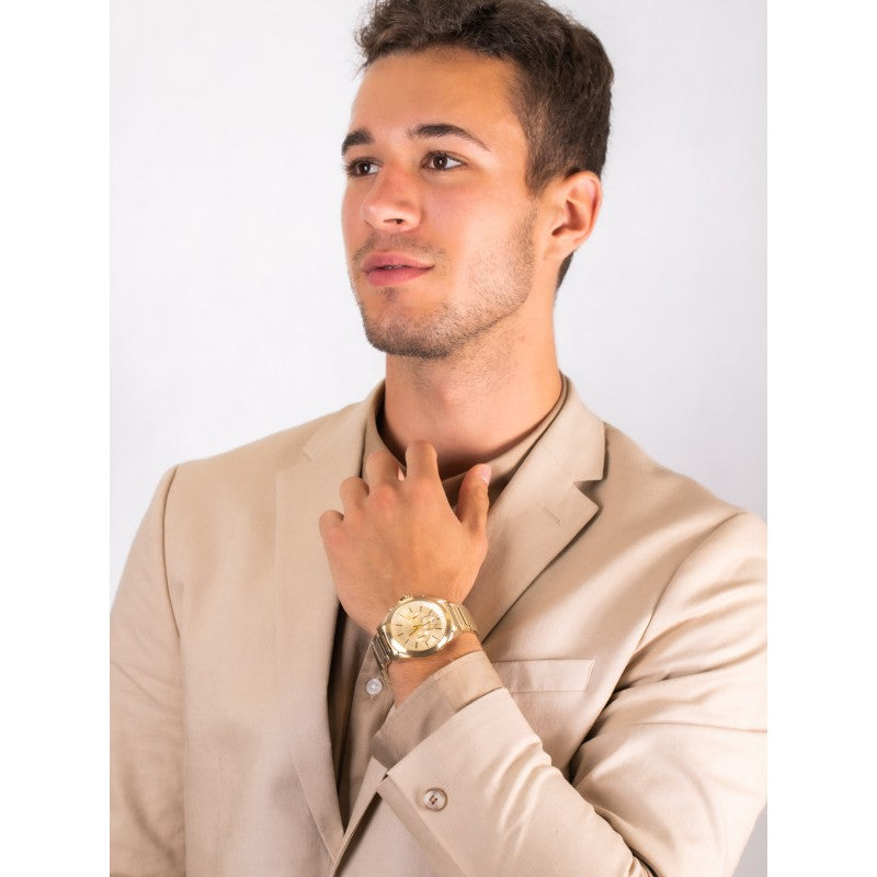 Man wearing a gold watch and tan suit.