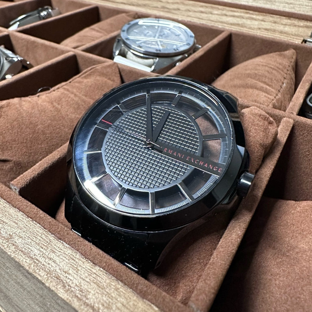Black Armani Exchange watch in a watch box.