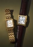 Two gold rectangular wristwatches.