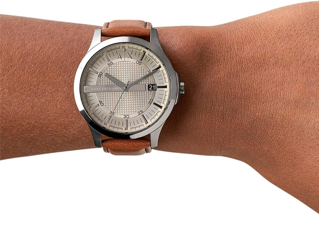 Silver watch with brown leather band on wrist