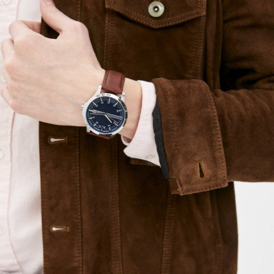 Man wearing a watch and brown jacket.