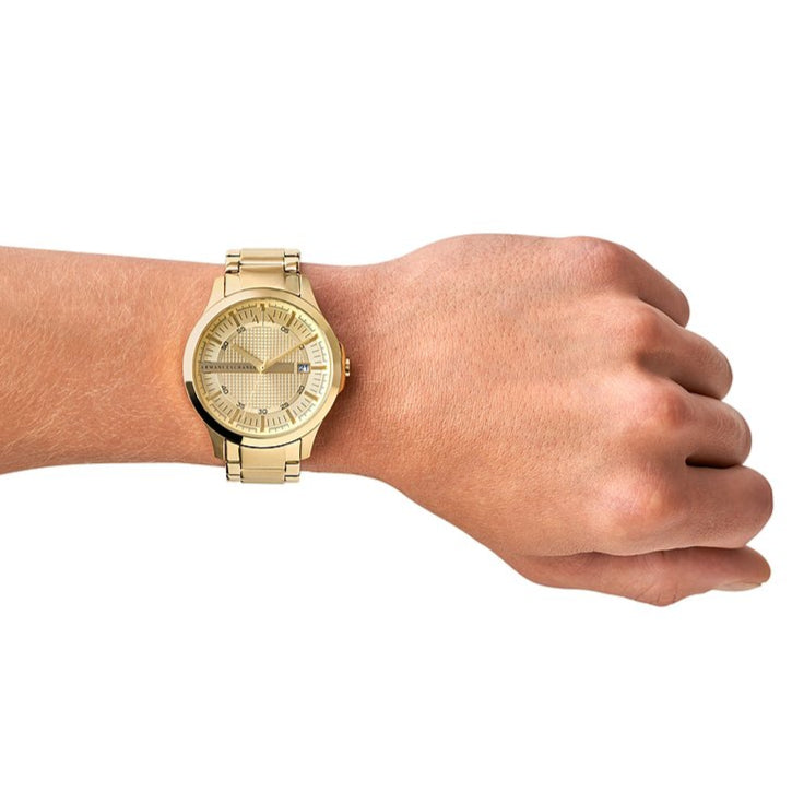 Gold wristwatch on a wrist.