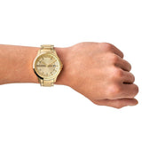 Gold wristwatch on a wrist.