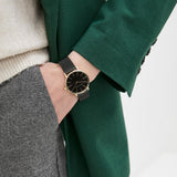 AX5548-5 black watch on wrist with gold accents, green jacket.