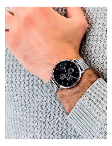 Men's watch on wrist with black face and silver band