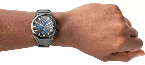 Man's wrist wearing a grey chronograph watch.
