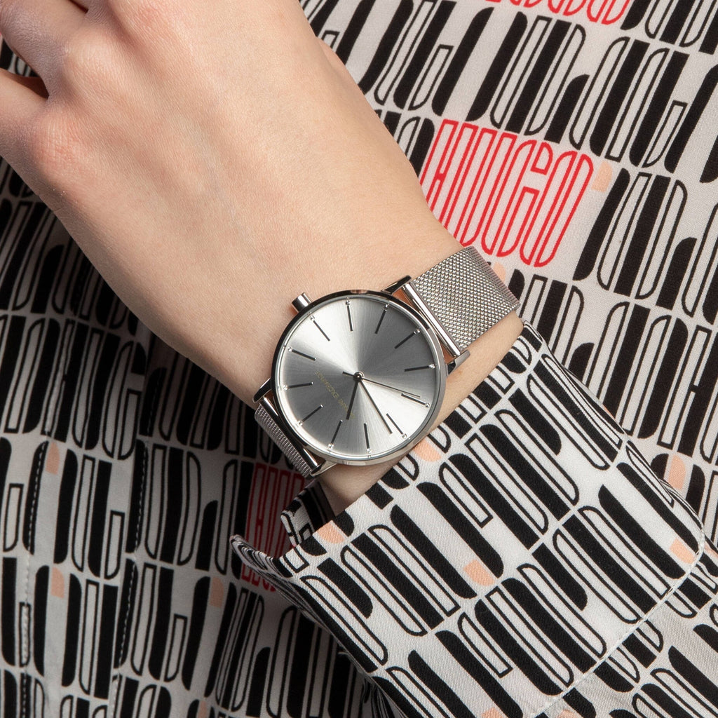Silver watch on wrist with Hugo Boss pattern