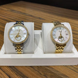 Two gold and silver watches on display.