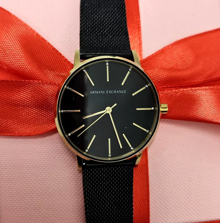 Armani Exchange black watch with gold accents and red ribbon.