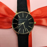 Armani Exchange black watch with gold accents and red ribbon.