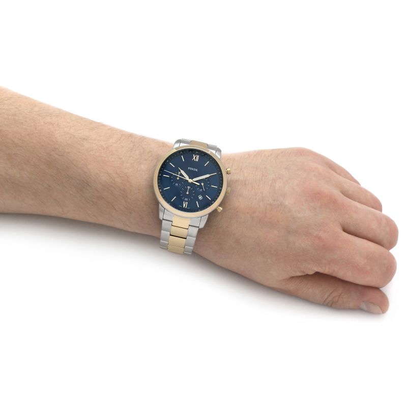 Wrist wearing a gold and silver watch.