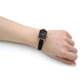 Wrist with a black watch.