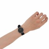 Person wearing a black watch on their wrist.