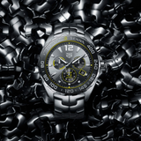 Silver wristwatch on a dark, textured surface.