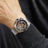 Man's wrist with a silver watch.
