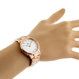 Rose gold wristwatch on a wrist.
