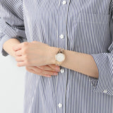 Woman wearing watch on wrist, striped shirt.