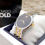 Movado gold and silver wristwatch on white cushion.