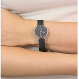 Wristwatch with black band on wrist.