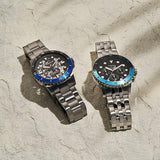 Two Fossil watches with blue accents on stone surface