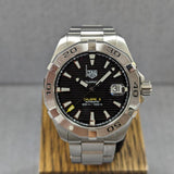 Silver wristwatch with black face and date display.