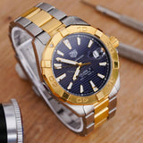Gold and silver wristwatch with blue face.
