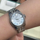 Silver wristwatch on a wrist.