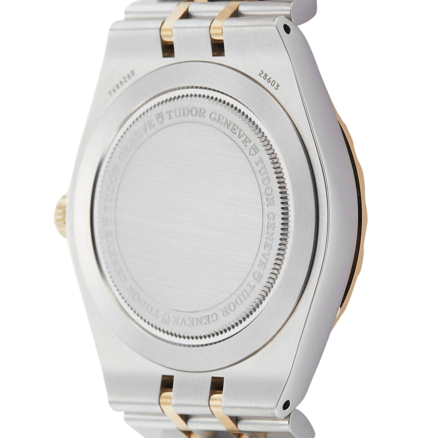 Back of a silver and gold watch with text.