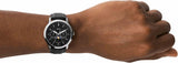 Fossil watch on wrist, black dial, product image.