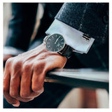Man's hand with watch and suit cuff.
